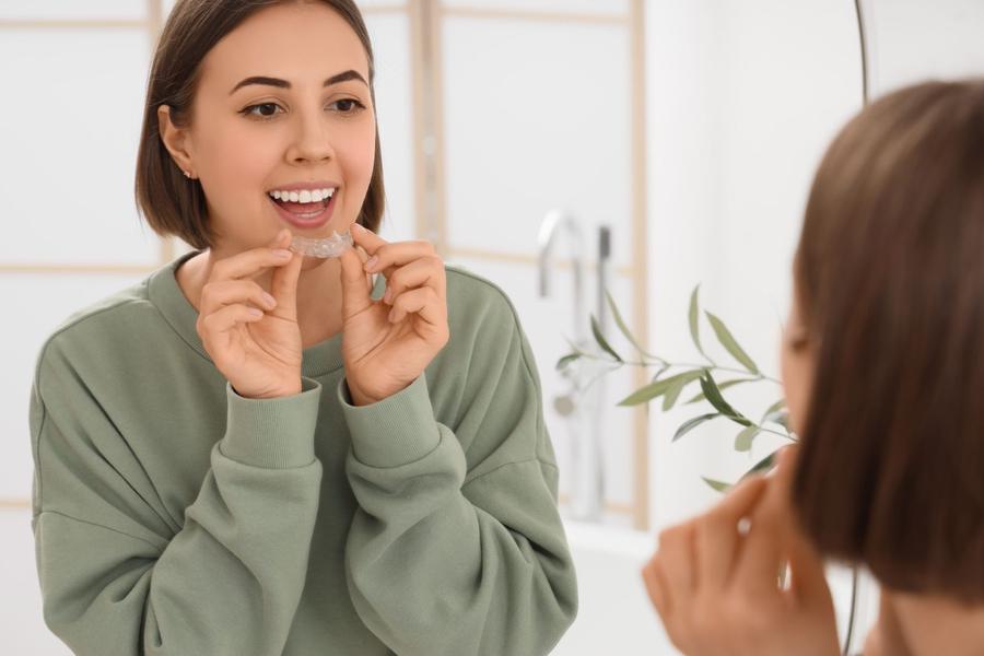 A woman placing a clear aligner