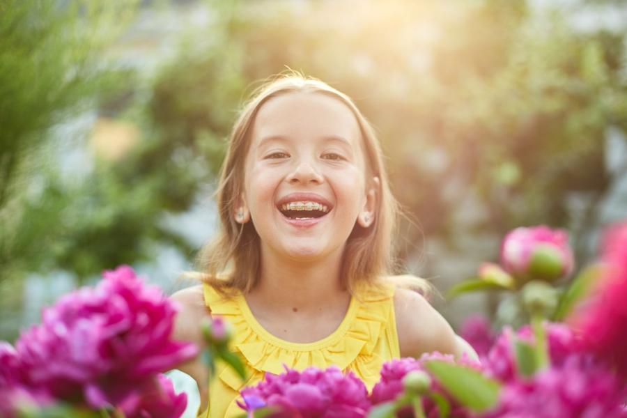 A young girl with braces smiling outdoors